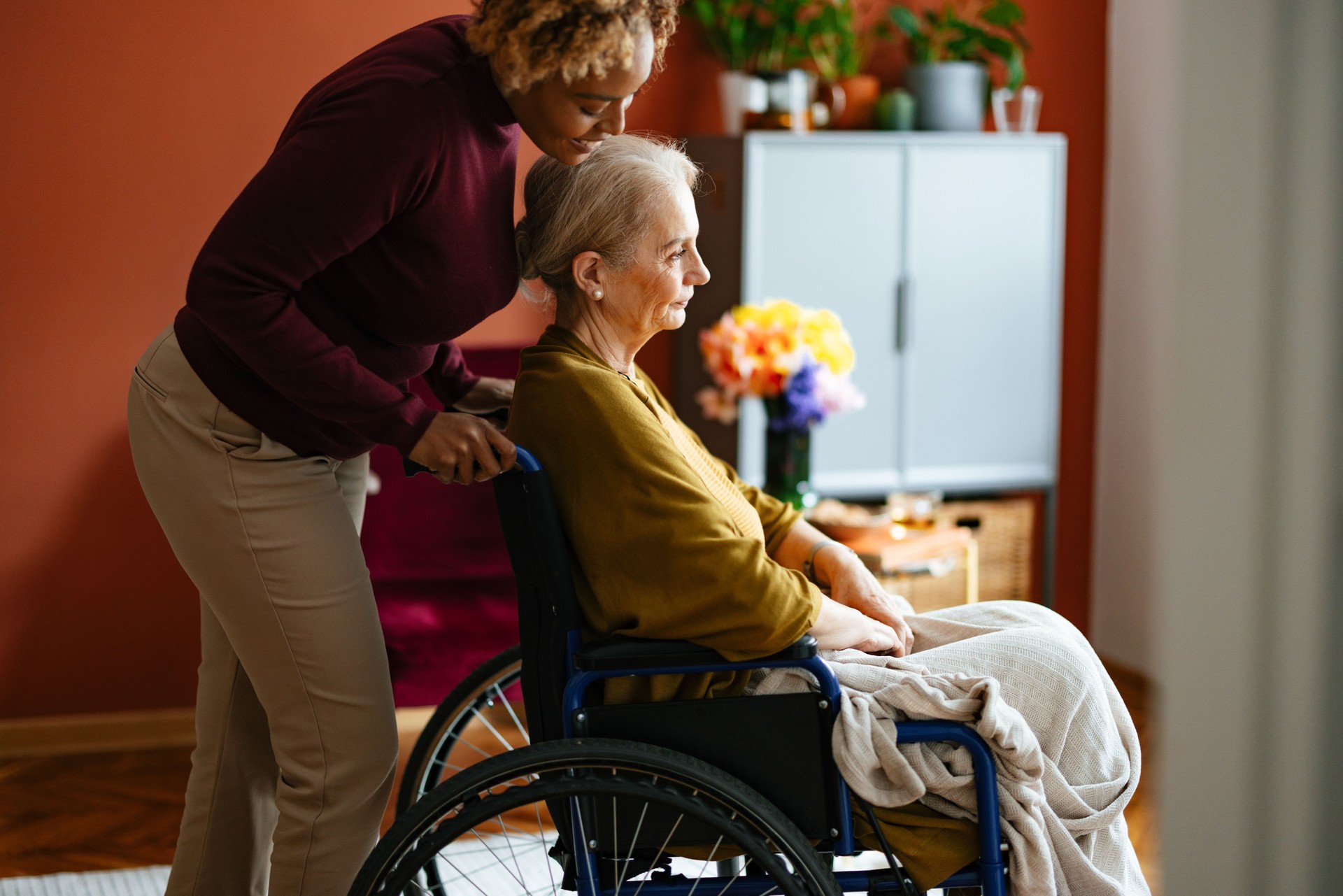 Compassionate Caregiver Assisting Senior Woman in Wheelchair