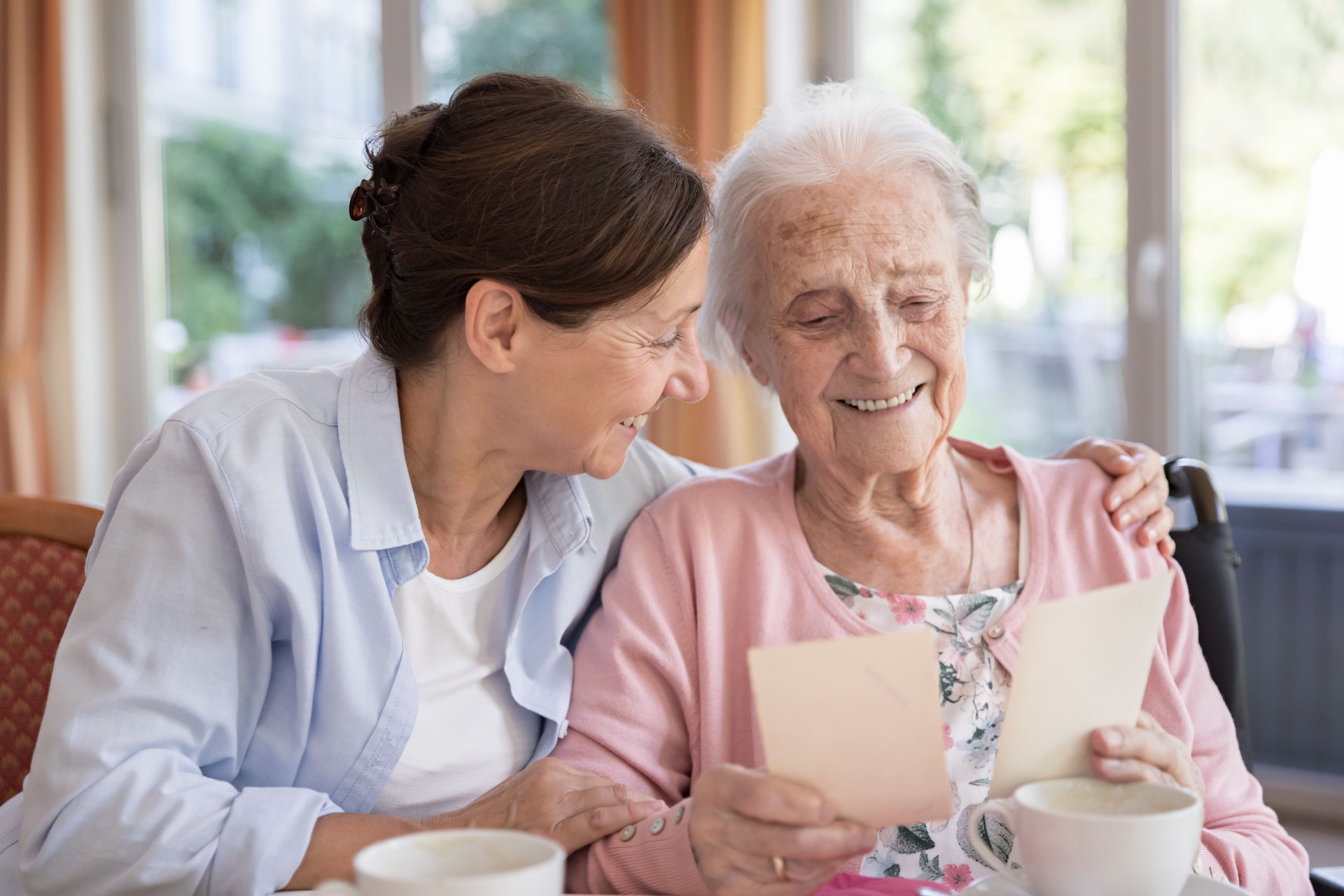 Happy senior woman in wheelchair with caregiver